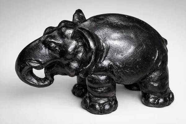 A black elephant sculpture with a curled trunk