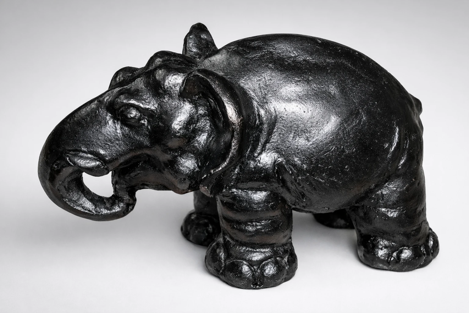 A black elephant sculpture with a curled trunk