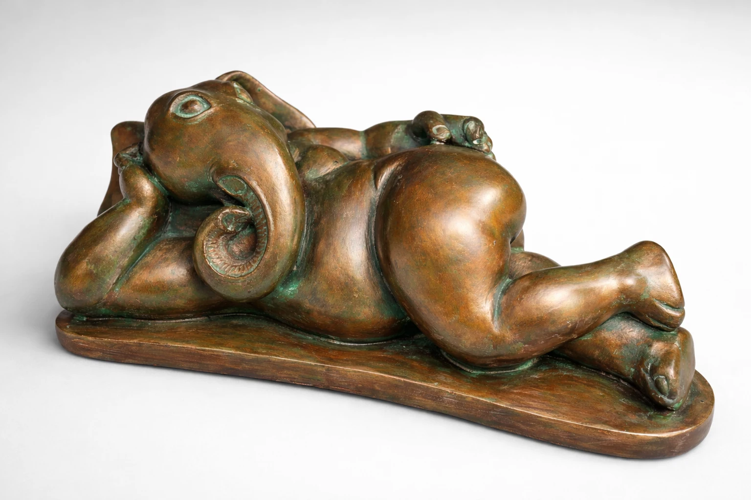 A reclining elephant sculpture with a bronze-coloured finish