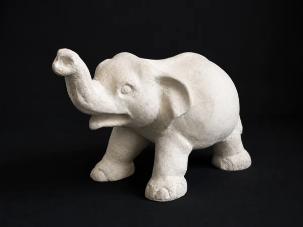 A white elephant sculpture with its trunk raised