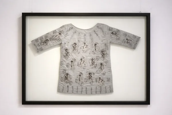 A framed kurta blouse covered with embroidered portrait images