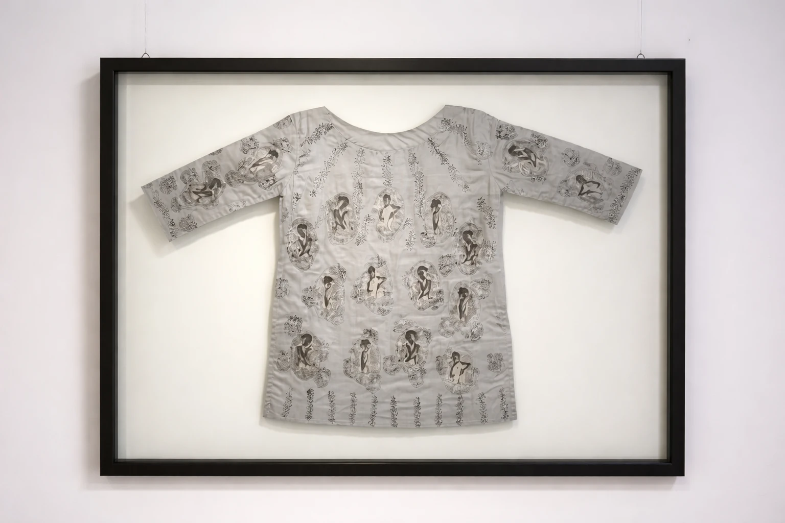 A framed kurta blouse covered with embroidered portrait images