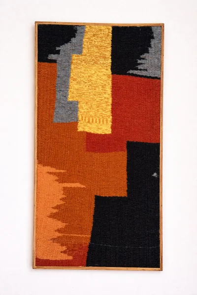 A geometric tapestry in burnt orange, gold, cream and black