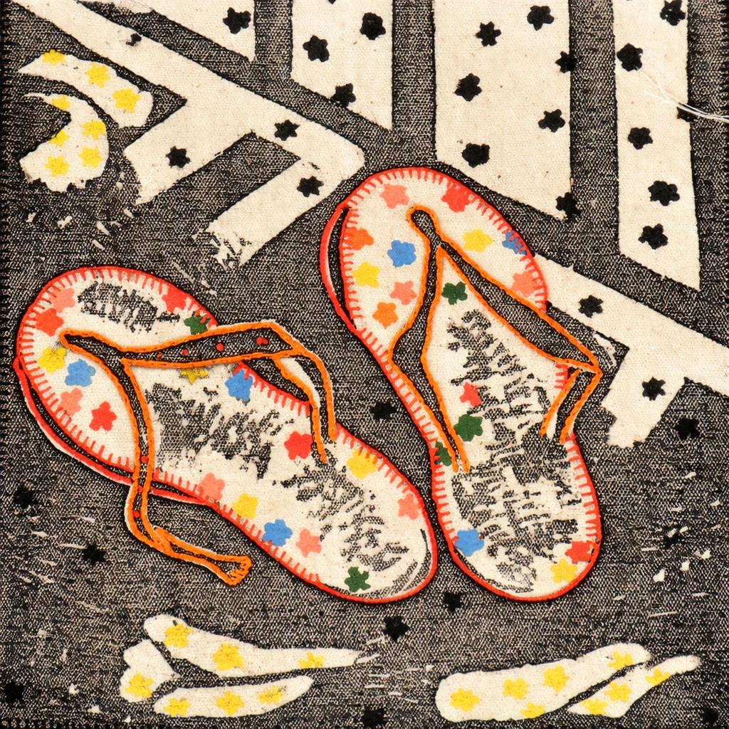 Brightly embroidered slippers on a patterned textile ground
